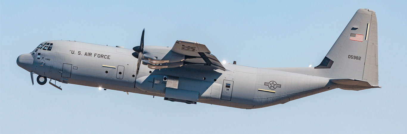 A C-130J Super Hercules aircraft flies on a blue sky background.